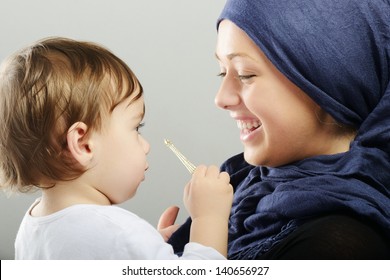 Arabic Muslim Mother Playing And Taking Care Of Her Baby