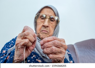 Arabic Muslim Old Woman Inserting Thread In Needle