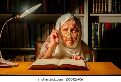 Arabic Muslim Old Woman Reading Books At Night With Table Lamp Light