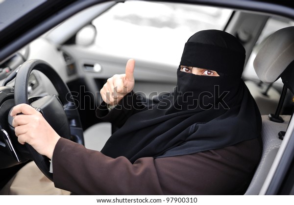 Arabic\
Muslim woman driving a car and happy for\
that