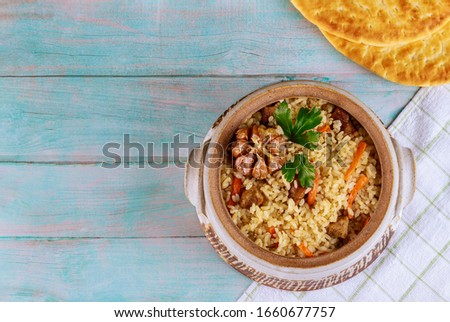 Arabic rice with vegetable and beef in blue plate on wooden background.