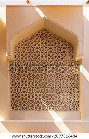 Arabic style mosque window with carved stone openwork, example of Islamic art, Dubai, United Arab Emirates.