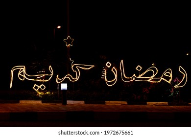 An Arabic text (Ramadan Kareem) which means Ramadan is generous made with led lights in the street as a festive sign celebrating the holy month in Islamic countries in middle east - Shutterstock ID 1972675661