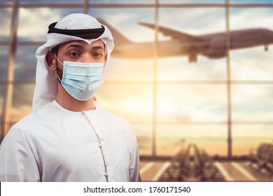 Arabic Traveler Business Man Wearing Mask Waiting To Board Into Airplane, Standing In Departure Terminal In Airport.  Arab Passenger Traveling By Plane Transportation During Covid19 Virus Pandemic.