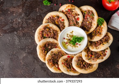 Arabic or turkish mini pizza Lahmacun on dark stone background. Selective focus. Toned image