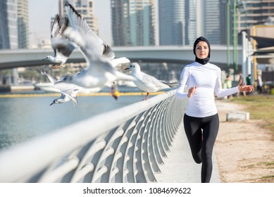 Arabic woman running outdoor and wearing hijab - Powered by Shutterstock