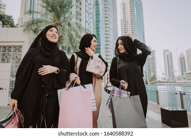 Arabic Women With Abaya Bonding And Having Fun Outdoors - Happy Middleastern Friends Meeting And Talking While Shopping