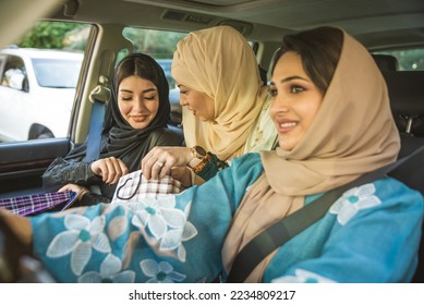 Arabic women with abaya bonding and having fun outdoors - Happy middl eastern female friends meeting and talking while shopping - Shutterstock ID 2234809217