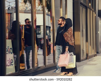 Arabic Young happy couple with shopping bags in the city. 