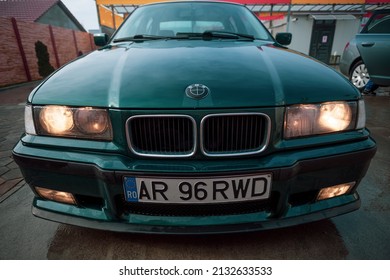 ARAD, ROMANIA - Dec 31, 2021: A closeup shot of a green BMW Sport e36 in a garage in Arad, Romania