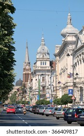ARAD, ROMANIA - JULY 30, 2015: domes and bell tower of University Aurel Vlaicu, City Hall Palace and Evangelical Church along a busy Revolution Avenue of Arad.