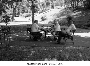 ARAD, ROMANIA - Mar 12, 2018: A greyscale shot of people playing chess in Mihai Eminescu Park in Arad, Romania