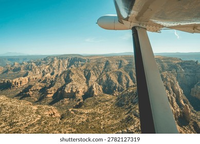 Arafed view of a mountain range with a plane flying over it.