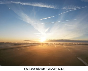 Arafed view of a sun setting over a field with a plane