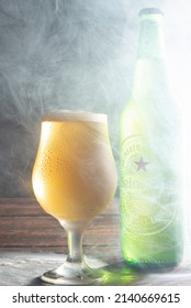 Araras, São Paulo, Brazil, March 29, 2022. Heineken Bottle And Cup Shrouded In Smoke Photographed With Dark Background, Selective Focus.