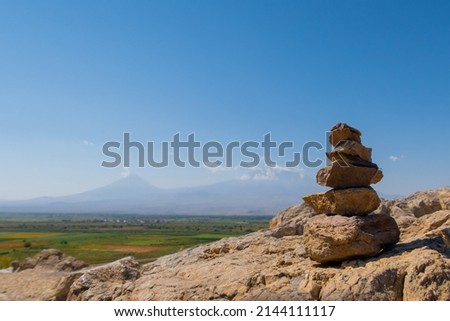 Ararat mountain vineyards with rocks cairn scenic view on the hill by Khor Virap monastery. Grape field in Ararat valley. Armenia picturesque mountain range landscape. Stock photo
