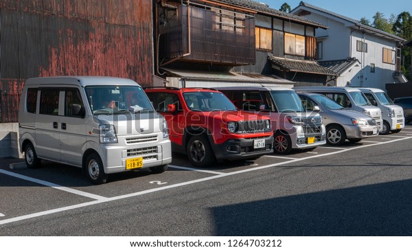 ARASHIYAMA, JAPAN-NOVEMBER 11, 2018 : Various Kei\
cars park in reverse in Arashiyama, Japan. Kei cars will have\
yellow plate\
number.