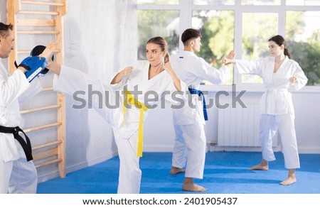 arate trainer helps a woman learn how to kick during karate training Imagine de stoc © 