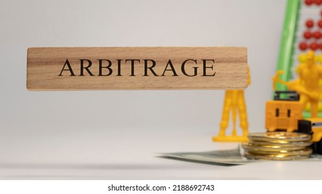 Arbitrage Sentence Written On Wooden Surface. Economy And Concept