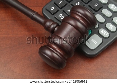 Arbitration and audition concept. Wooden judge gavel and calculator on table close up.