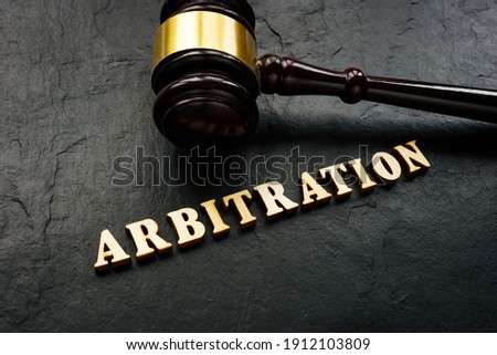 Arbitration word from wooden letters and gavel in court.