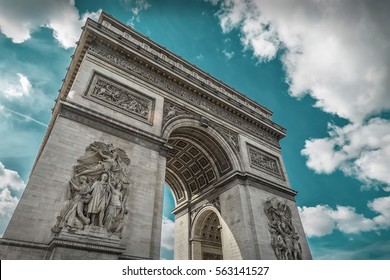 Arc de Triomphe in Paris under sky with clouds. One of symbols of France and one of the most popular tourist places in the world.