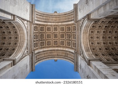 Arc de Triomphe seen from below. Detailshot of the Arc against blue sky.