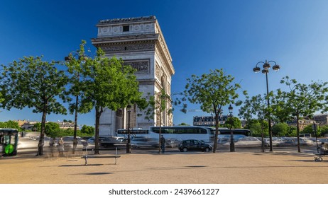 The Arc de Triomphe timelapse hyperlapse with traffic on circle road and trees around. Famous monument in Paris, standing at the western end of the Champs-Elyseees. Blue cloudy sky at summer day