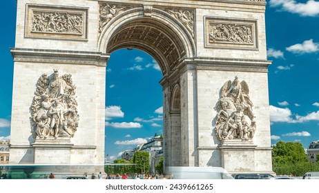 The Arc de Triomphe (Triumphal Arch of the Star) front view timelapse. Famous monument in Paris, standing at the western end of the Champs-Elyseees. Traffic on a circle road. Blue cloudy sky at summer