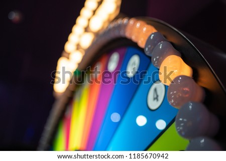 Arcade gambling machine up close. Giant wheel with colorful sections and lights.