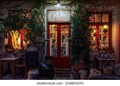 Arcadia, Greece - February 25 2022: traditional Greek tsipouro empty tavern decorated facade with sign, illuminated at night in Lagadia village at Peloponnese region.