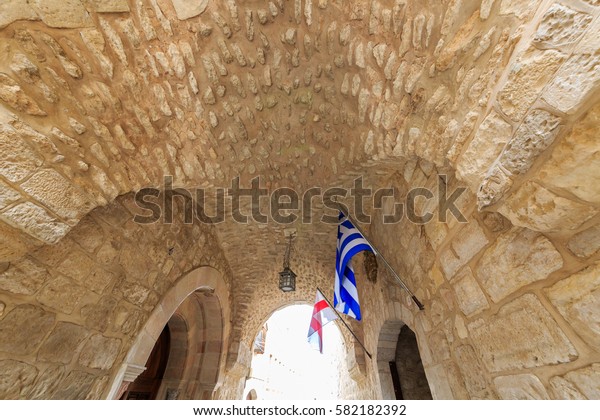 Arch in the Christian quarter of\
the Old City of Jerusalem with the Greek and Georgian\
flags