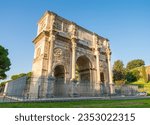 Arch of Constantine at sunrise in Rome. Text translation "Senate dedicated this Arch to Constantine"