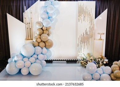 Arch decorated candles and brown, gold, and blue balloons for the wedding ceremony. Celebration Birthday concept. Trendy flowers decor and photo wall. A place for text. Trendy autumn decor.