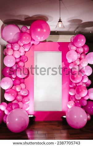 Arch decorated with pink balloons. A bright pink photo zone for a hen party or bachelor party. Photo wall decoration space, place with white background. Trendy decor. Birthday party for girl.
