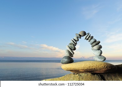 Arch of pebbles in balancing on the seacoast