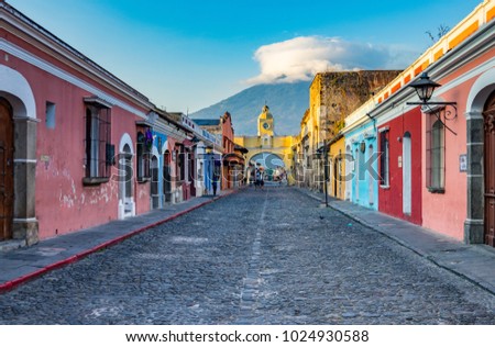 Arch Street of Antigua Guatemala featuring the Santa Catalina Arch and the Agua Volcano in the background.