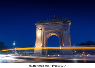 Arch of Triumph (Arcul de Triumf) building in Bucharest Romania during the evening with traffic lights at bottom of it