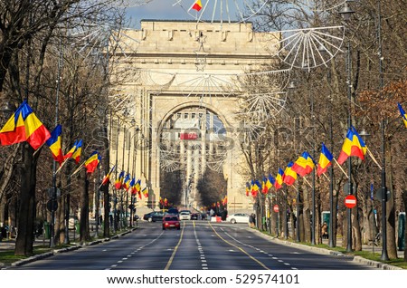 The Arch of Triumph (Arcul de Triumf) from Bucharest Romania, National Day with romanian flags, view from Kisseleff Avenue.