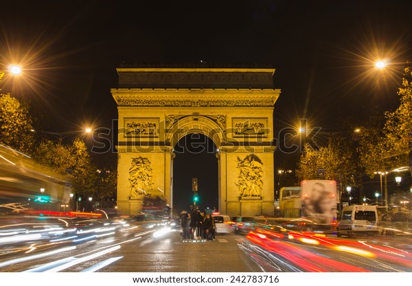 Arch of\
Triumph of the Star (Arc de Triomphe de l\'Etoile) in Paris (France)\
at night. Traffic in\
Champs-Élysées.
