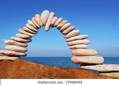 Arch of white pebbles in the balance on the seacoast - Shutterstock ID 179580944
