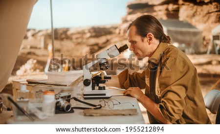 Archaeological Digging Site: Great Male Archaeologist Doing Cultural Research, Discovers Ancient Civilization Historical Artifacts, Fossil Remains at Excavation Site, Study it Under Microscope