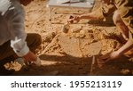 Archaeological Digging Site: Two Great Archeologists Work on Excavation Site, Carefully Cleaning, Lifting Newly Discovered Ancient Civilization Cultural Artifact, Historic Clay Tablet. Focus on Hands