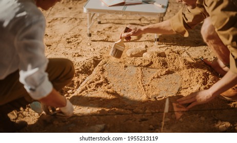 Archaeological Digging Site: Two Great Archeologists Work on Excavation Site, Carefully Cleaning, Lifting Newly Discovered Ancient Civilization Cultural Artifact, Historic Clay Tablet. Focus on Hands