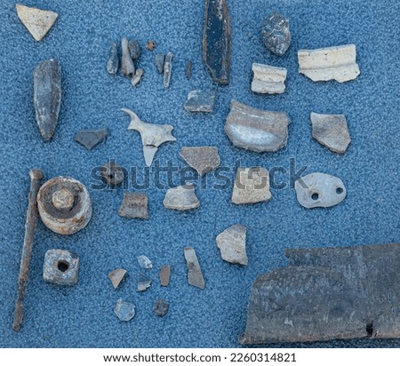 Archaeological method of raising artefacts. On Novgorod Volkhov River bank found: flakes, spearhead, vessel shards 12th-17th, fishing sinkers, terra cotta, cow shale figurine, metalwork of 20th cent