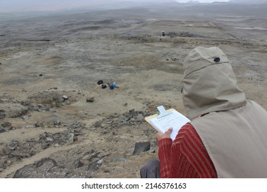 An Archaeologist In His Field Work Filling Out With Information In An Excavation At An Archaeological Site