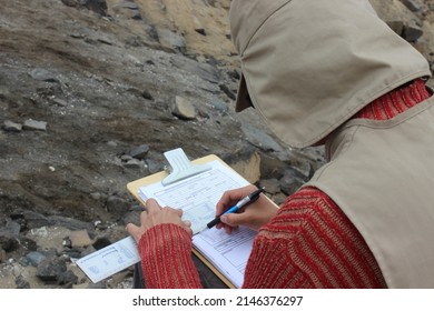 An Archaeologist In His Field Work Filling Out With Information In An Excavation At An Archaeological Site