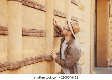 Archaeologist Man In Hat Looking Ancient Buildings. Concept Travel Tour Guide Archeological Old City.