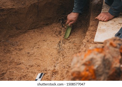 archaeologists with hands in sterile gloves clean of sand and earth found during the expedition ancient artifact, neat work of historians