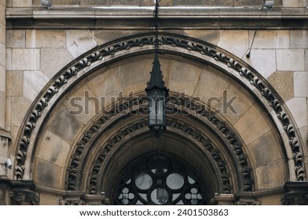 Arched doorway with part of a round window with stained glass and antique iron lantern. Fragment of the facade. Baroque and Gothic architecture. Church of Saints Olga and Elizabeth. Lviv, Ukraine. Stock photo © 